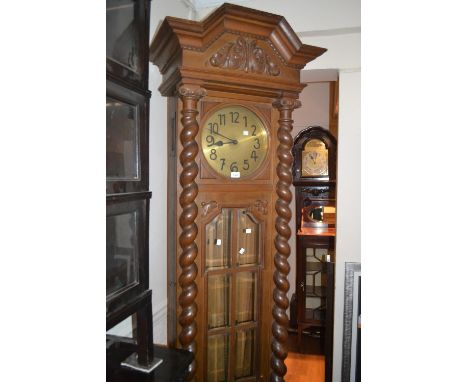 Early 20th Century oak longcase clock, the shaped moulded pediment with a carved floral cresting above a circular dial and be