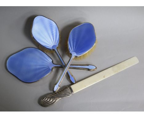 A silver and enamel three piece brush set and a silver handled ivory page turner.