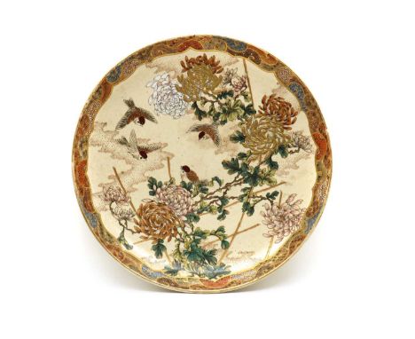 A large Japanese Satsuma ware charger, Meiji period (1868-1912), of circular form, painted with birds among chrysanthemum, en