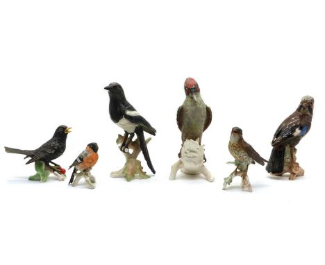 A Goebel green woodpecker, 1975, polychrome, perched on a tree stump,28cm high together with five further examples by Goebel,