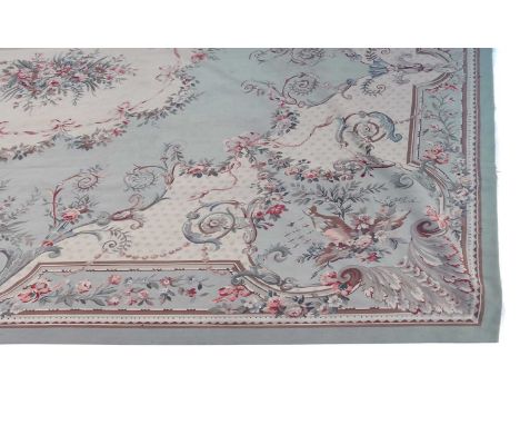 A large Aubusson style carpet,20th century, the green ground with central medallion inset with a bouquet of flowers, the twin