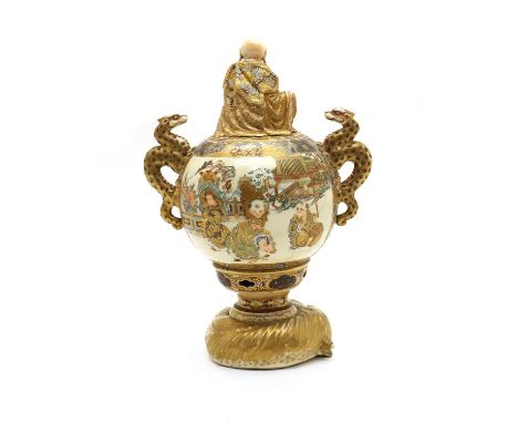 A Japanese Satsuma ware koro,Meiji period (1868-1912), of globular form rising from a recumbent Buddhist lion, flanked by two