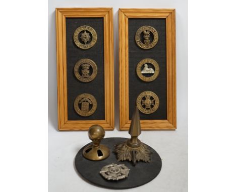 Six military helmet plates mounted on two boards, together with two helmet spikes and a cap badge, including; the Yorkshire R