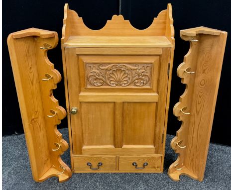 An Ash wood spice cabinet, the three-quarter galleried shelf to top, above a single door with carved panel, enclosing three t