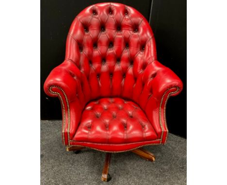 A chesterfield office chair, ox-blood red leather, button-back, rotating, rise-and-fall base. 