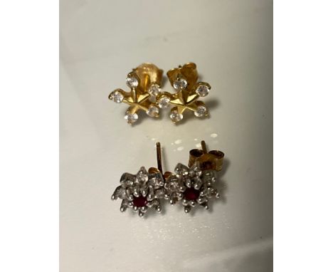 A pair of diamond and ruby earrings, central red ruby surrounded by eight round brilliant cut diamonds, 9ct gold mounts, 1.7g