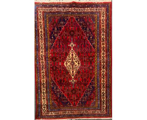 A North West Persian Hamadan Carpet, multi-tones of cream, blue, green and yellow, red filed, 302cm x 208cm 