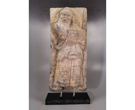 Ca. 386-534 AD. A rectangular ceramic tile with recess to the obverse, facing nimbate standing figure of Chinese soldier, for
