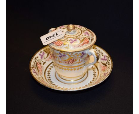 A Spode twin-handled chocolate cup and trembleuse stand, painted in tones of puce, red and gilding with flowerheads, berries 