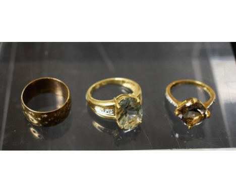 Rings - a 9ct gold mounted smoky quartz solitaire ring;  a pale blue stone dress ring;  a 9ct gold star cut wedding band, 12.