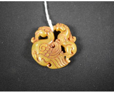 A jade effect roundel, dog of fo riding a dragon, 5cm diameter