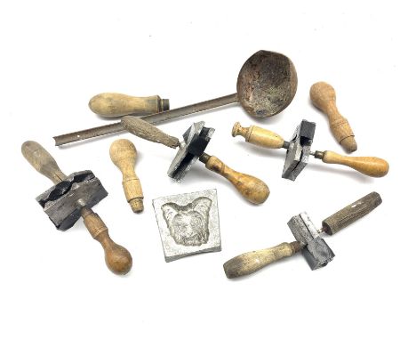 A group of lead modelling moulds, together with a pouring ladle 
