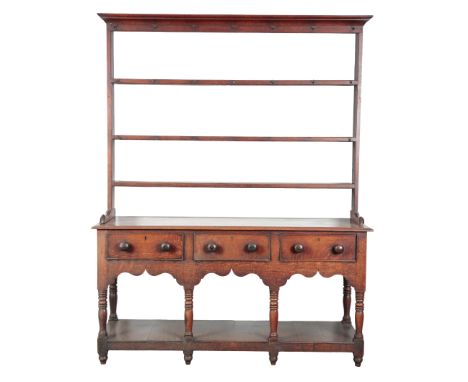 A PROVINCIAL OAK DRESSER19th century, the plate rack with three shelves and old iron hanging hooks, the base with three short