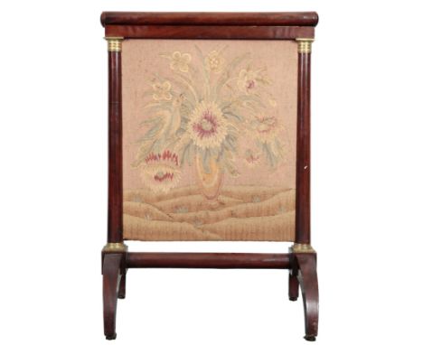 A FRENCH EMPIRE MAHOGANY FIRESCREEN inset with a needlework panel depicting a bird in a vase of flowers, on tapered legs term