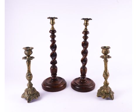 A PAIR OF GEORGE III STYLE SPIRAL TURNED OAK CANDLESTICKS (4)With foliate cast drip-pans, 43cm high; Together with a pair of 