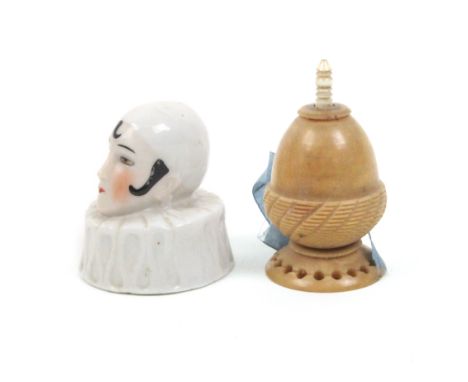 Two tape measures comprising a continental porcelain example in the form of a Pierrot head with ruff collar, tape shortened, 