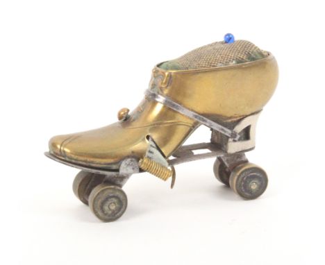 A brass and steel novelty tape measure/ pincushion in the form of a roller skate, tape shortened to 2ins, 6.5cm