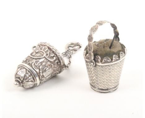 A silver thimble case and a silver pincushion the thimble case of tapering form embossed with leaf scrolls and tapering to a 