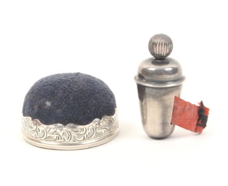 A silver tape measure and pincushion, the tape measure of tapering cylinder form, ball winding finial, near complete printed 