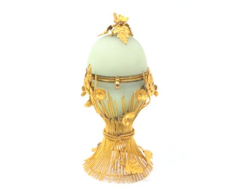 A French gilt metal and green opaque glass table etui, circa 1880, for a child or doll, the glass egg within gilt wirework, f