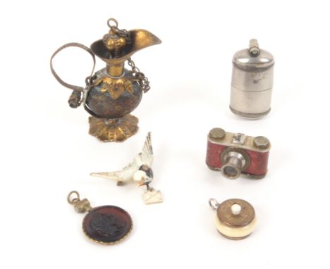 Six charms and novelties all with Stanhopes comprising a gilt brass scent bottle as a ewer, dents to body, (four views _ A Me