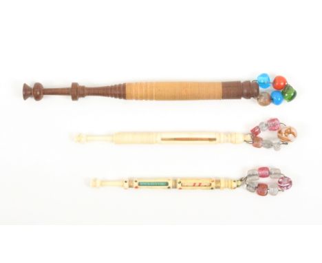 Three bobbins incorporating miniature bobbins comprising a two colour turned wooden example, parting below the spangle to rev