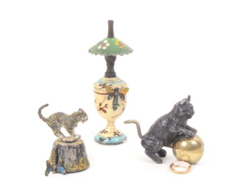 Three metal novelty tape measures comprising an example as an oil lamp with floral painted decoration, the tape with butterfl