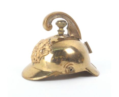 A rare brass novelty tape measure in the form of a firemanÍs helmet complete tape wound from the helmet finial, 5.5cm
