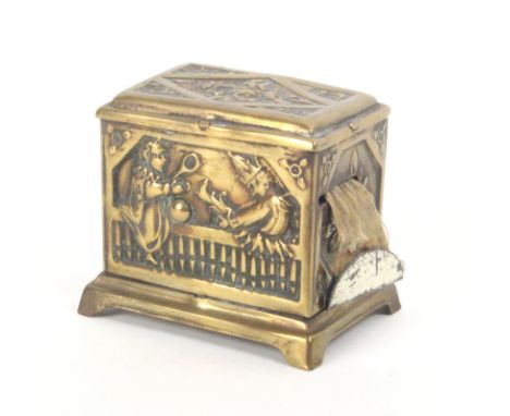 An embossed brass tape measure as a hurdy gurdy of rectangular form the front with Punch and Judy, playing a ñtuneî as the ta