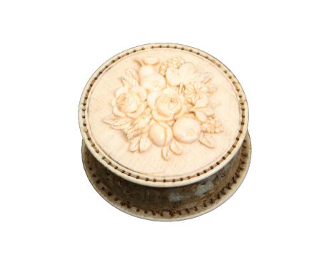 A fine 19th Century carved ivory disc form pincushion each side carved with a variant panel in relief of flowers, fruit and l