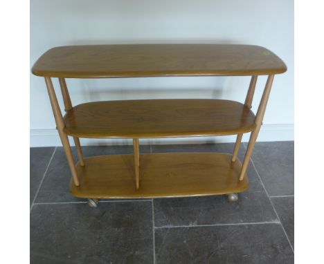 An Ercol Golden Dawn elm three tier side table book/magazine stand - Height 72cm x 91cm x 32cm - in good condition 