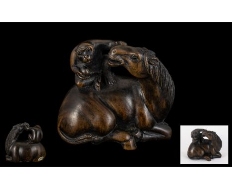 An Oriental Boxwood Netsuke in the form of a Monkey sitting on a Horse.  Realistically carved.  Excellent condition, signed s
