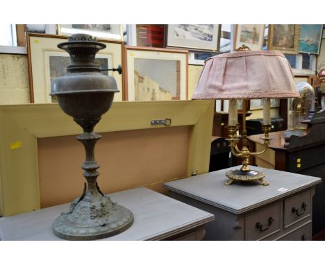 A Victorian brass oil lamp, with rams head decoration; together with a brass three branch table light.