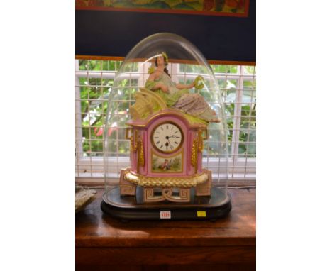 A late 19th century Continental porcelain mantel clock, with figural surmount, 45cm high on ebonized stand under glass dome. 