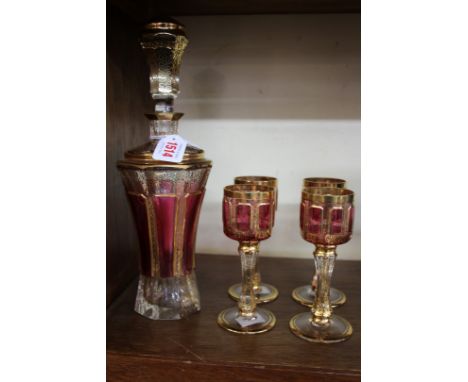 A Continental ruby flashed and gilt decorated decanter and stopper and four glasses, in the style of Egermann, 31cm high. 