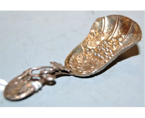 A Victorian silver caddy spoon, the bowl embossed with leaves and berries, having further leaf decoration to the handle