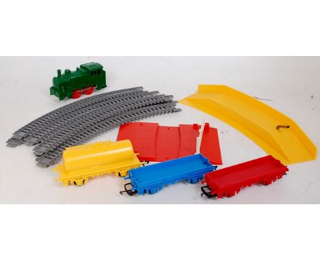 Parts of a Triang Hornby play train, green clockwork 0-4-0 tank engine, red, blue, flat wagons, container for one, yellow tan