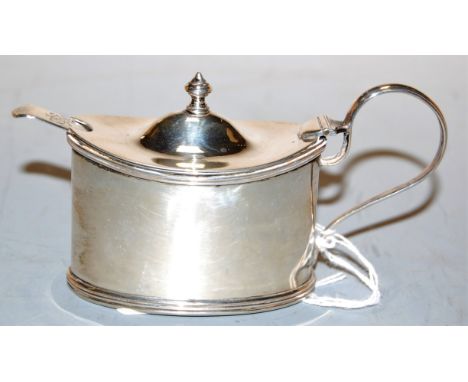 An Edwardian silver mustard, of plain undecorated oval form, having later ceramic liner, with associated spoon, maker Hillear