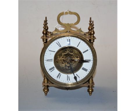 An early 20th century brass cased mantel clock having a circular enamel dial with Roman numerals and visible escapement, heig