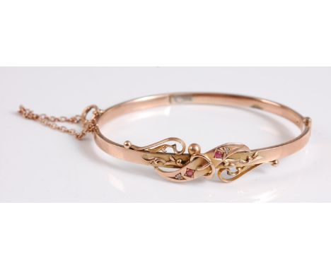 A 9ct ruby and diamond highlight hinged bangle, hallmarked for 9ct gold, Birmingham 1906, with safety chain, 6cm wide, (7.1g)