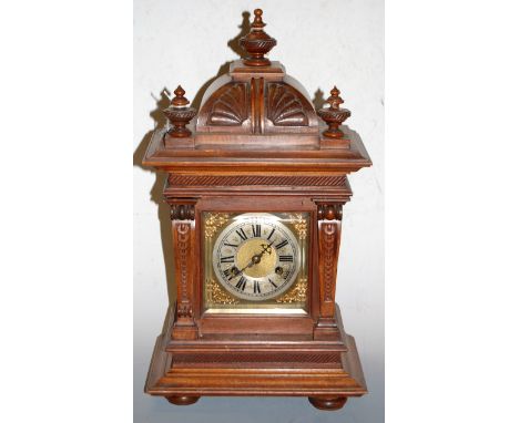 A late 19th century continental walnut cased mantel clock having a silvered dial with Roman numerals and eight day movement s