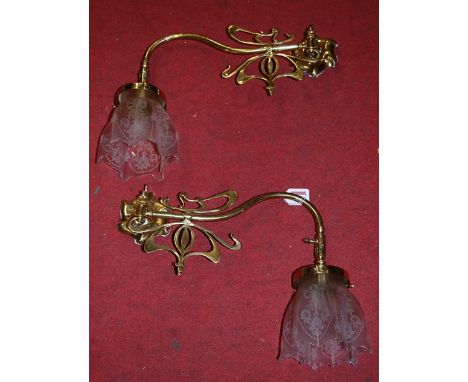 A pair of Art Nouveau style lacquered brass single sconce wall light fittings, each having a pinched clear glass shade. Adapt