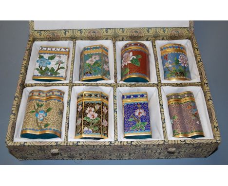 A set of eight Chinese cloisonne jars and covers each enamel decorated with flowers in fitted case