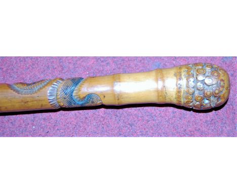 An early 20th century bamboo walking stick, carved with sinuous snakes