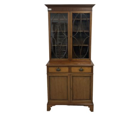 Early 20th century inlaid mahogany bookcase on cabinet, projecting dentil cornice over two astragal glazed doors enclosing ad