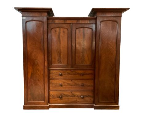 Victorian mahogany turret press wardrobe, tall flanking arch panelled doors enclosing hanging rail and coat hooks, central do