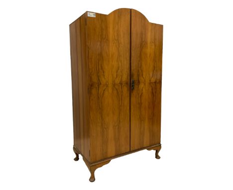 Early 20th century figured walnut, stepped arch top, enclosed by two doors, the interior fitted with shelves and drawerDimens