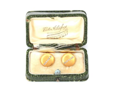 A pair of 14 karat gold cufflinks, set with diamonds. Round classic model, matted, set in a line with seven rose diamonds in 