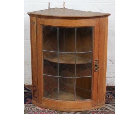 A carved light oak corner cabinet, with lead glazed door, 60cm x 40cm