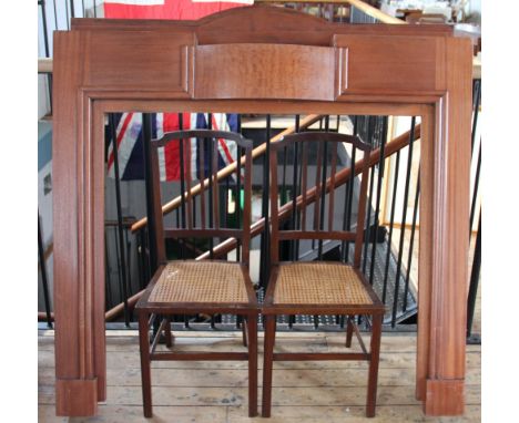 A 1950's fire surround in architectural style, 135 high, 135 wide and a pair of mahogany bedroom chairs with cane seats (3)